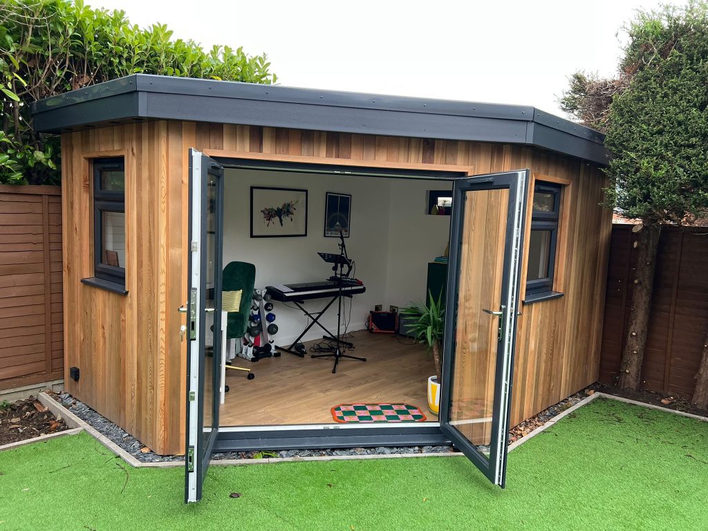 Compact corner garden room with natural wood cladding and glazing